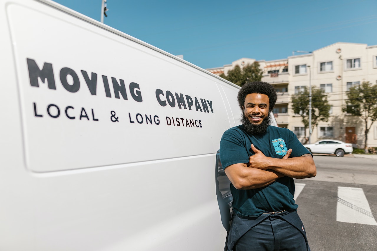 a mover nest to a moving van smiling