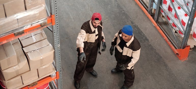 two men in a warehouse talking about warehousing vs. inventory management