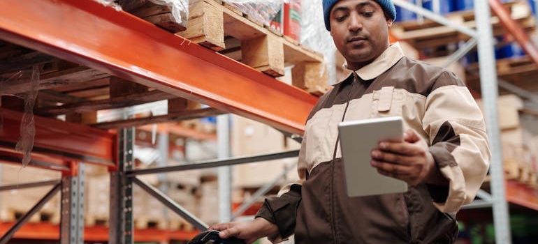 a man in a warehouse using an inventory list