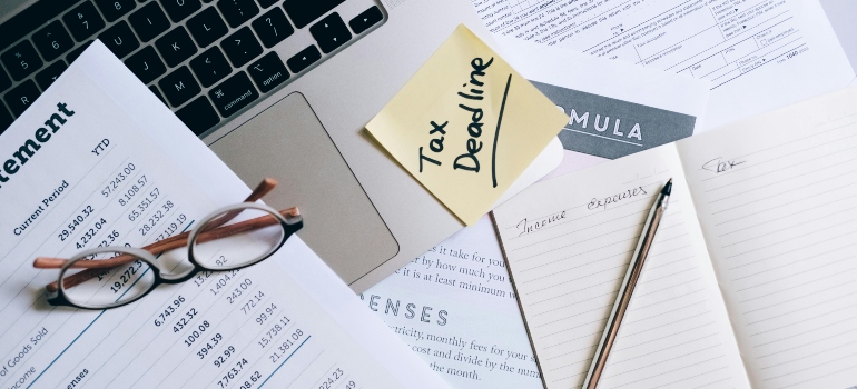 Tax deadline note on a desk surrounded by documents, emphasizing the importance of managing timelines and having a moving list.