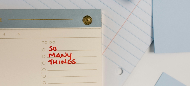 Close-up of a to-do list with "so many things" written, emphasizing the need for an ultimate moving checklist.