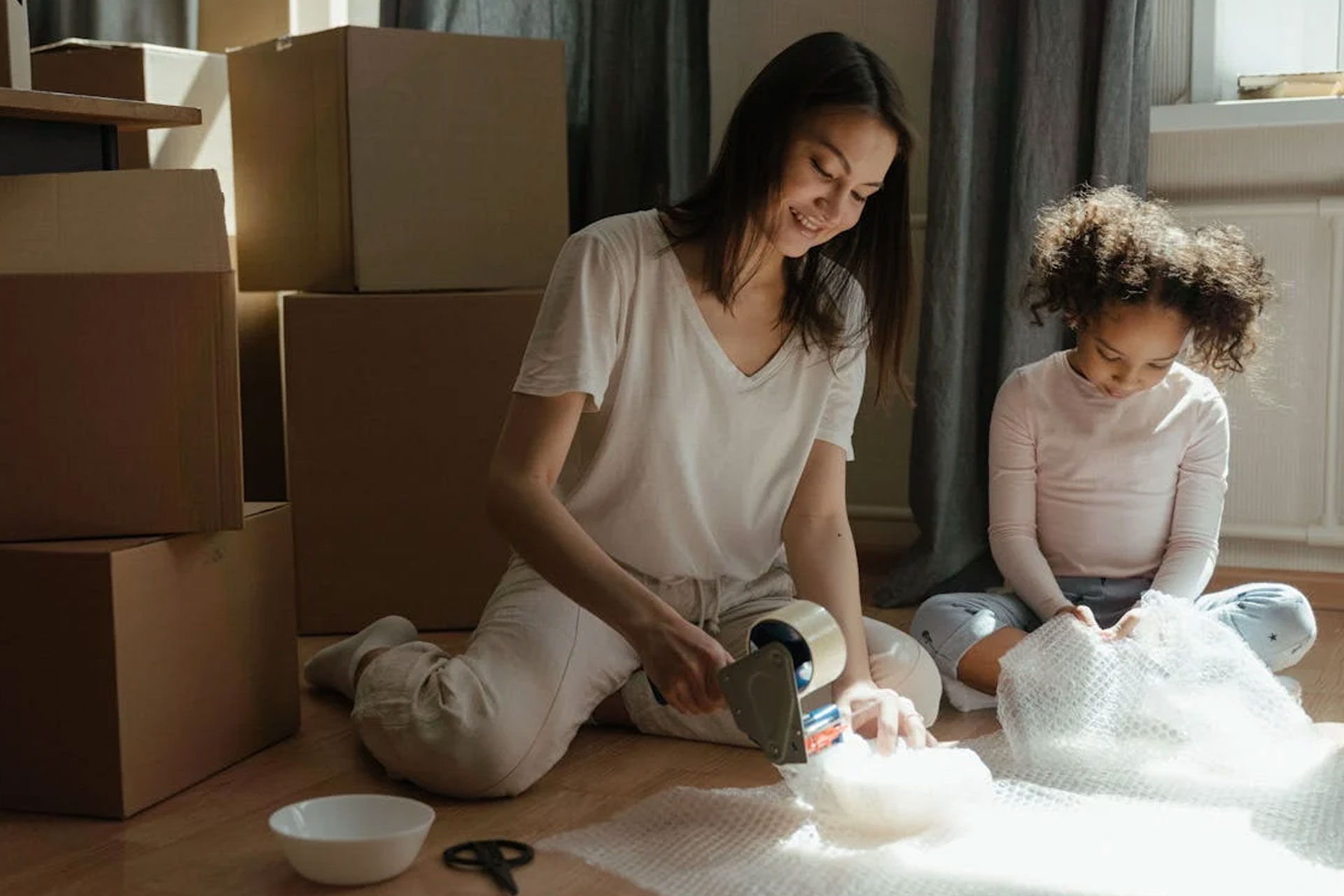 mother and daughter packing fragile items