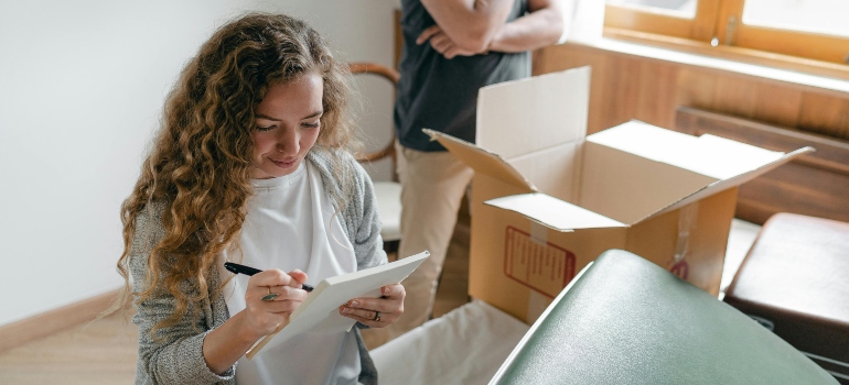 A woman diligently documenting items so that she doesn't forget how to pack fragile items when moving