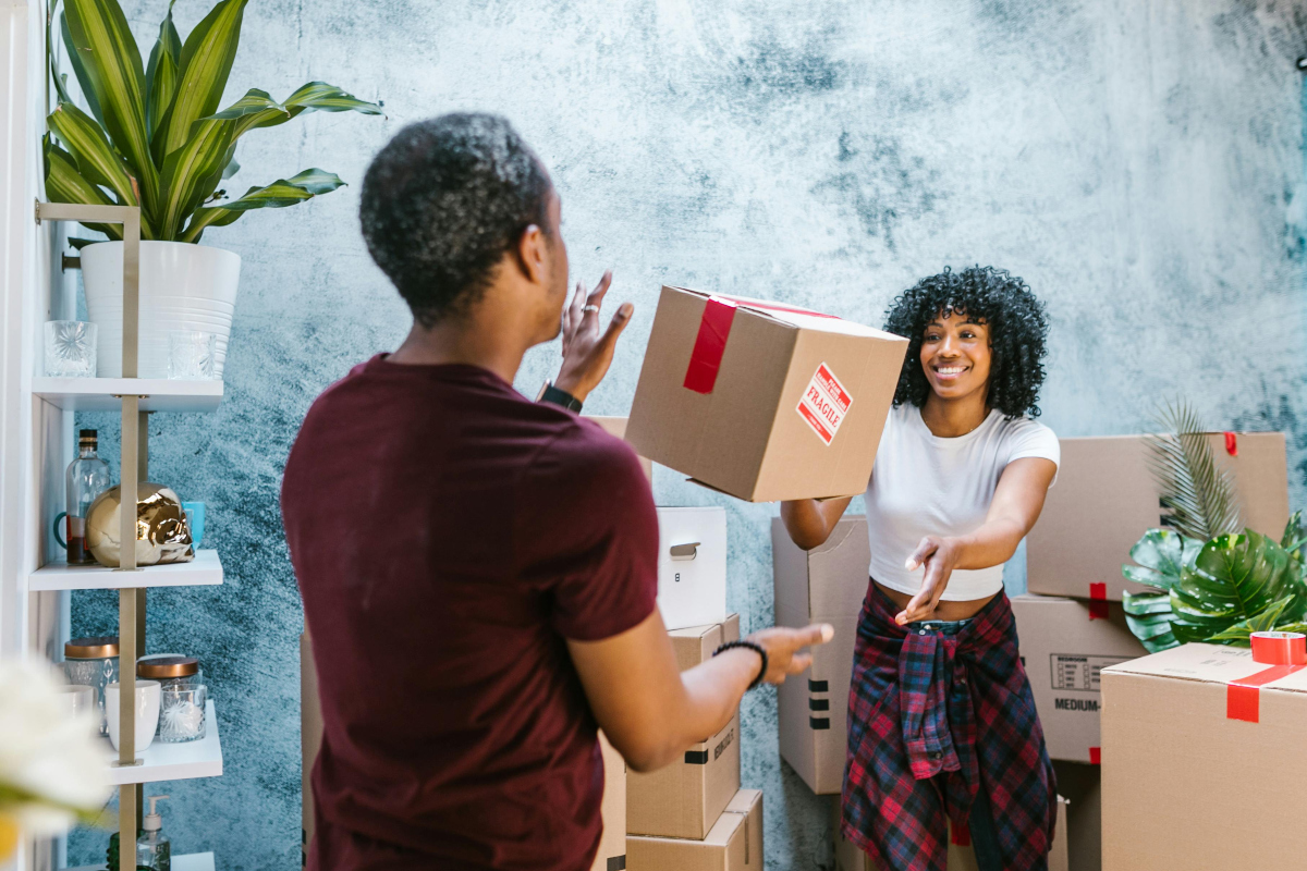 man throwing a box to a woman