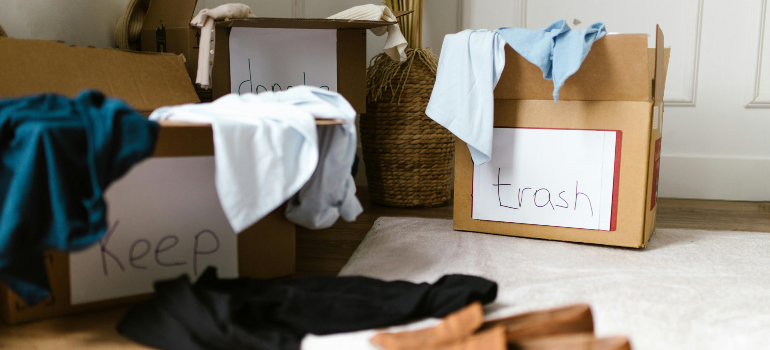 three boxes labeled keep, trash, and donate, which helps you understand how to downsize your belongings