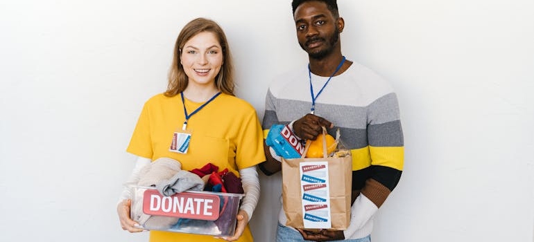two people holding boxes for donation
