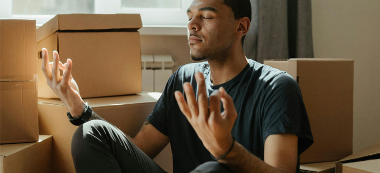 a man sitting among packed boxes waiting for movers Canton GA team