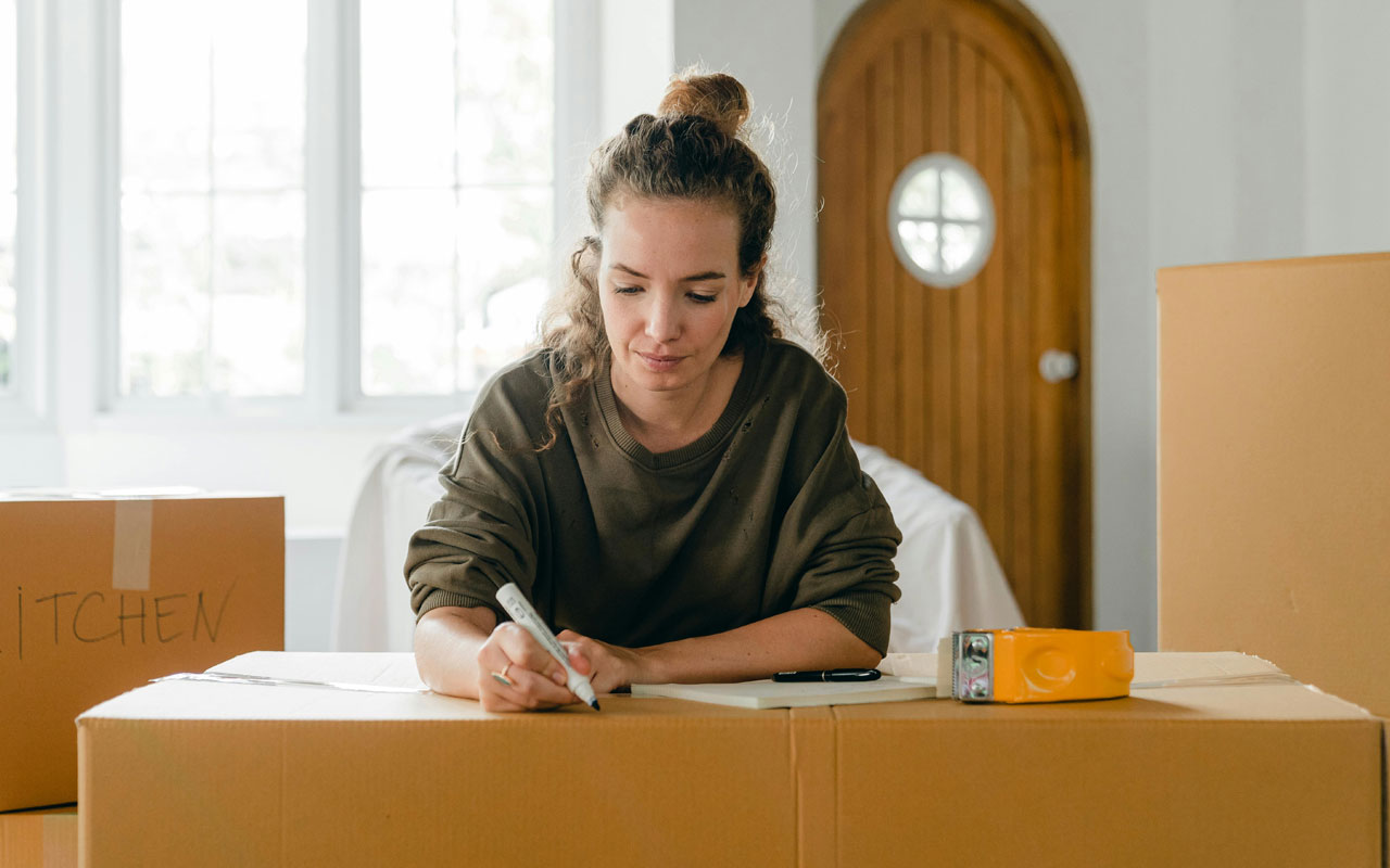 a woman writing on a box