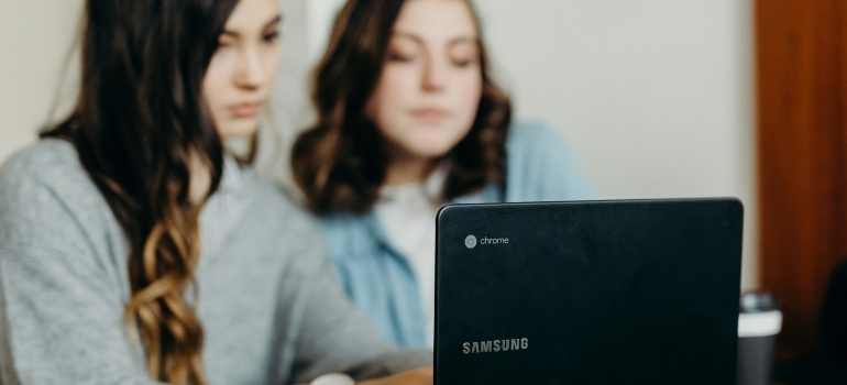 People looking at a laptop while researching the benefits of companies moving to Atlanta