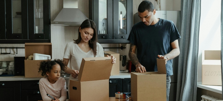 A family working together to unpack in their new kitchen after moving to Atlanta.