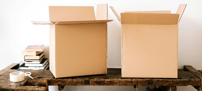 Two open cardboard boxes resting on a wooden table, prepared for a careful move by Peachtree movers GA.