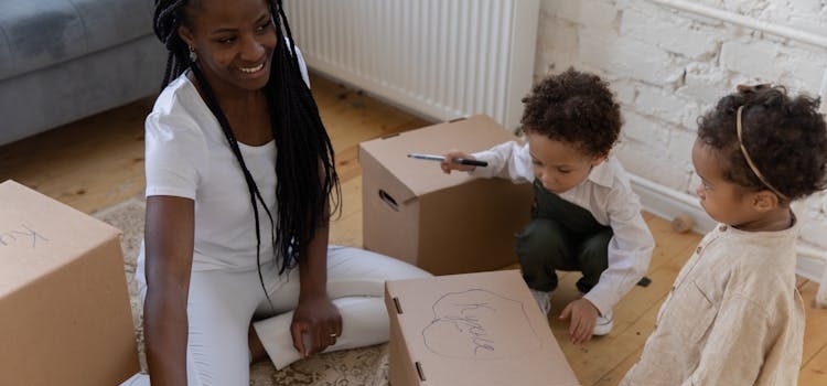 a woman packing with toddlers next to her