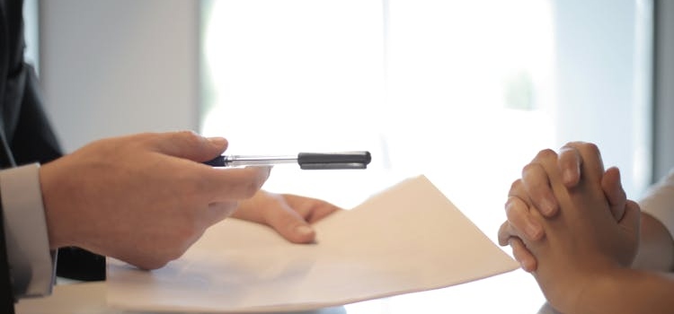 two people signing a contract