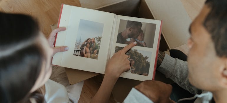 a couple packing old photos from a photo album