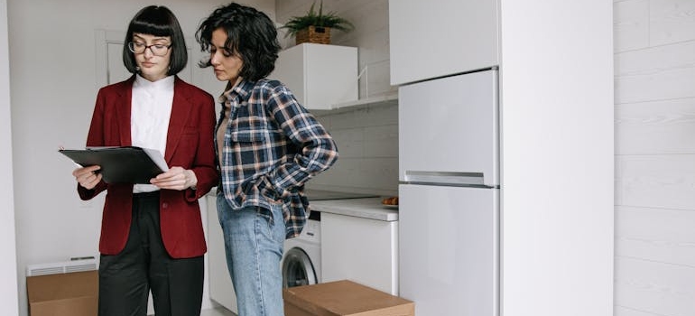 a real estate agent and a woman looking at a contract