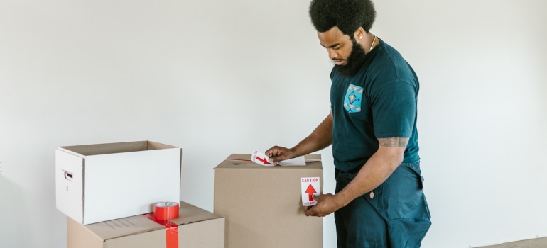 a mover labeling a box for relocating a home and family business simultaneously