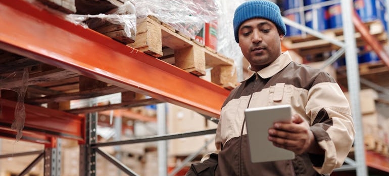 a man in a storage unit using a tablet and reading storage rules and regulations in Georgia 