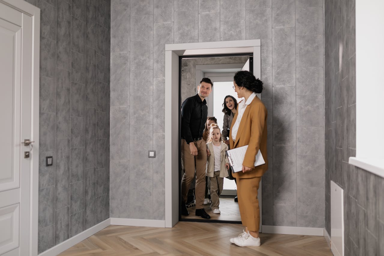 a family with a real estate agent inspecting a house