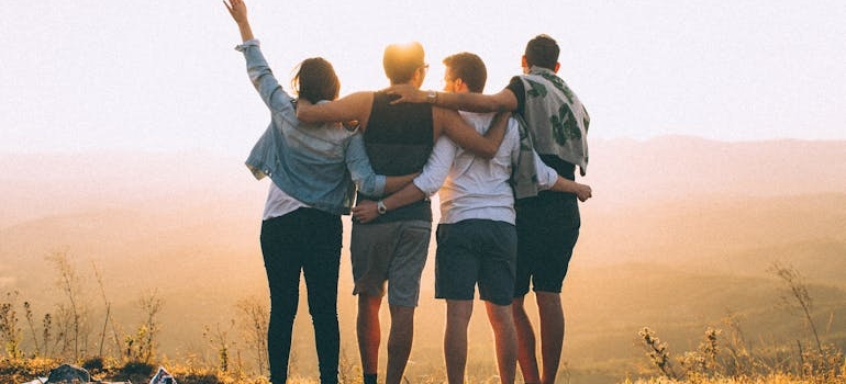 friends standing together at sunset in mountains
