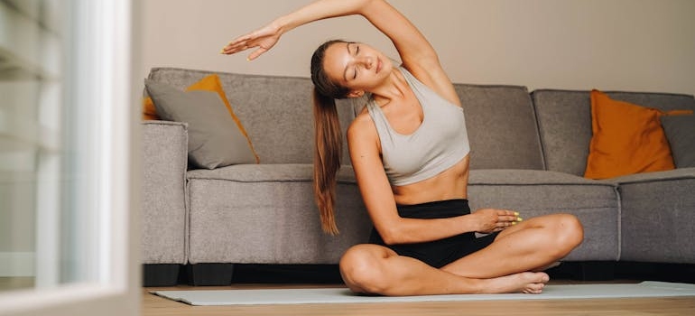 a woman doing yoga, staying active while relocating