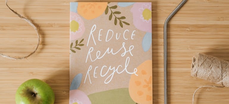 recycle, reuse, reduce written on a notebook cover