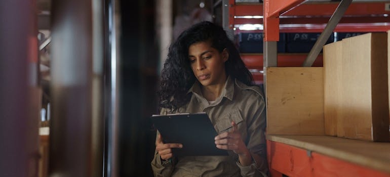 a woman in a storage unit checking inventory 