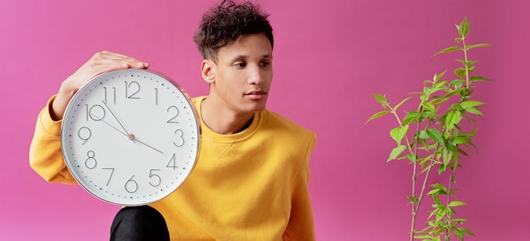 a person holding a clock thinking about moving help by the hour