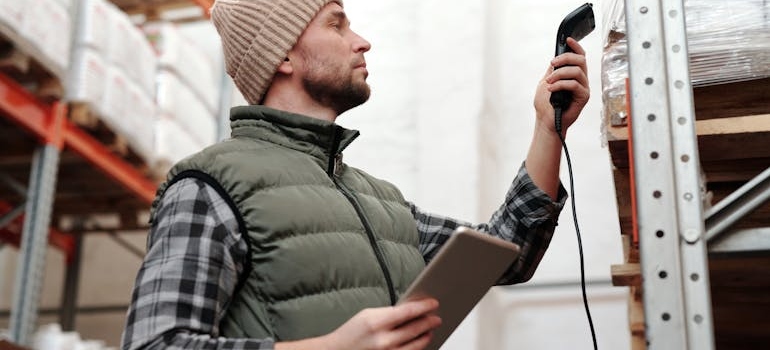 Photo of a Man Scanning Products in a Warehouse
