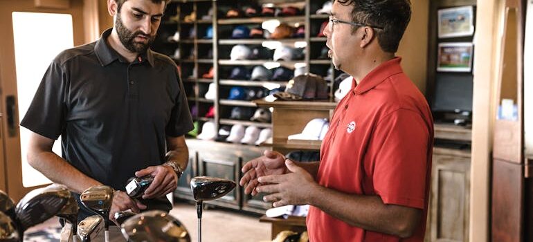 two men in a golf store speaking about relocating golf equipment