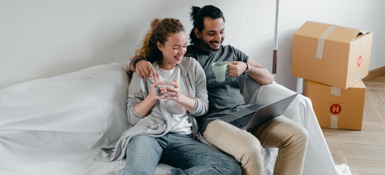 a couple browsing the internet for moving apps to organize your relocation
