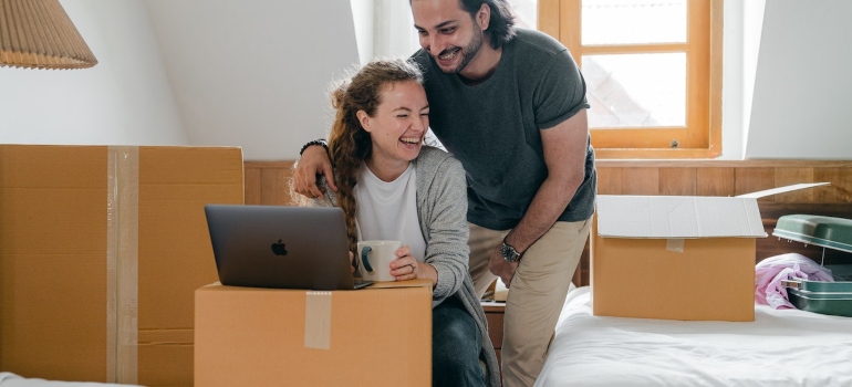 a couple searching the internet to choose a local mover
