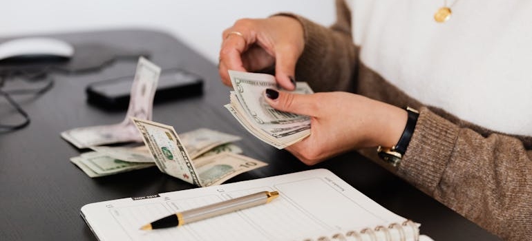 a woman counting money and trying to budget for temporary housing and storage 