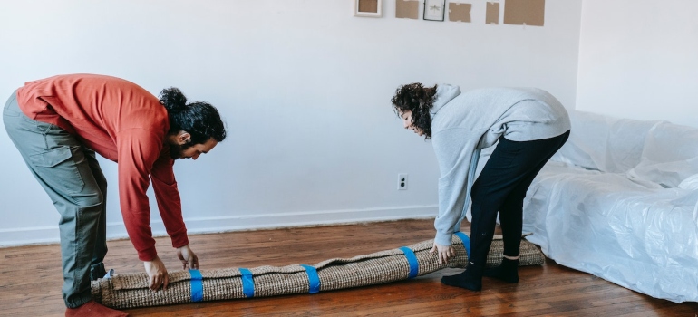 a couple folding a carpet