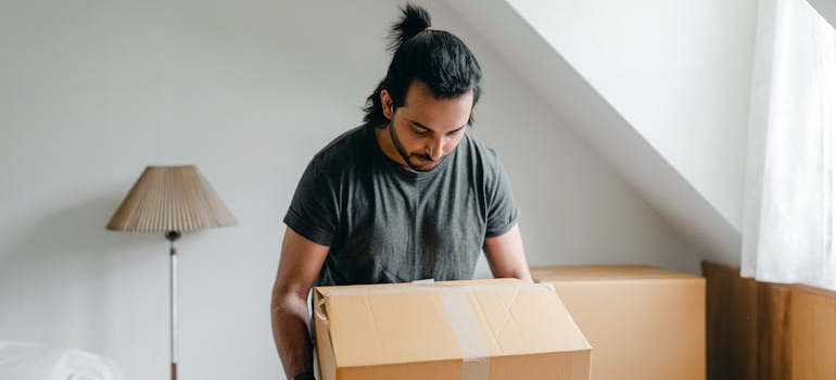 a man packing a box and decluttering attics and basements